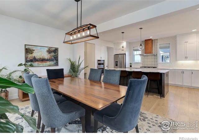 dining space featuring recessed lighting and light wood-style flooring