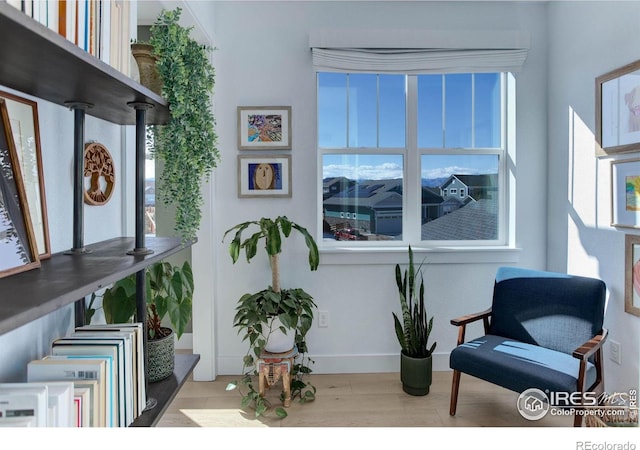 sitting room with baseboards and wood finished floors