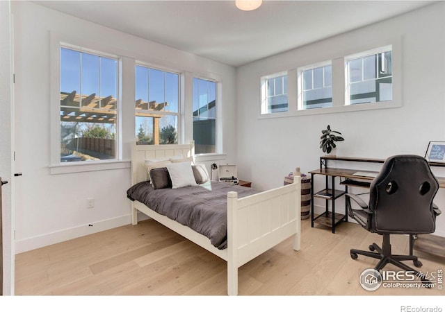 bedroom featuring baseboards and wood finished floors