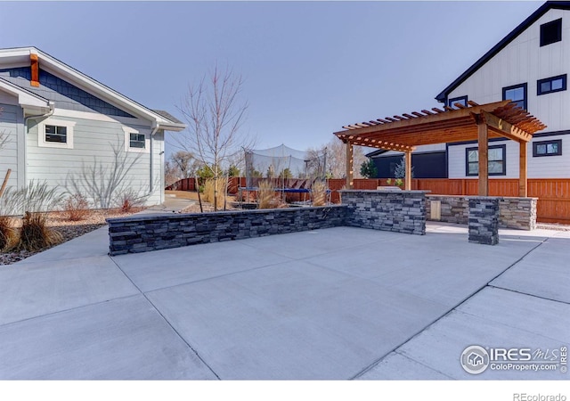 view of patio / terrace featuring a pergola, a trampoline, and fence