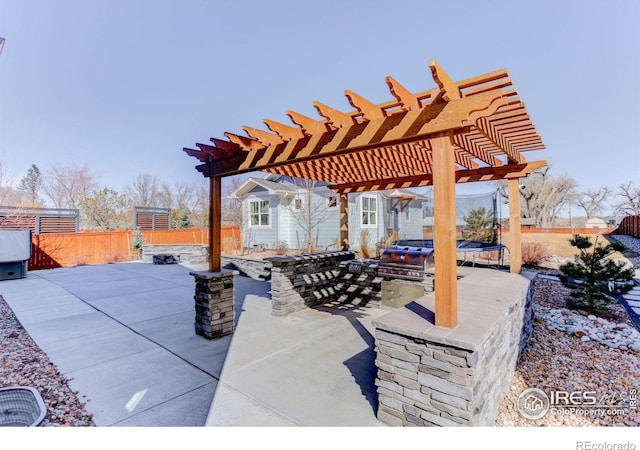 view of patio / terrace with a trampoline, a pergola, and fence