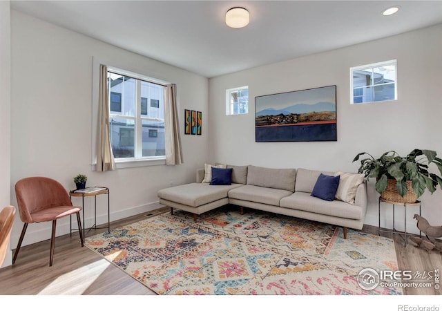 living room featuring recessed lighting, baseboards, and wood finished floors