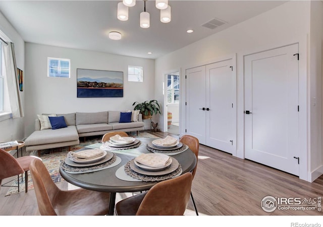 dining area featuring light wood-style flooring, a notable chandelier, recessed lighting, and visible vents