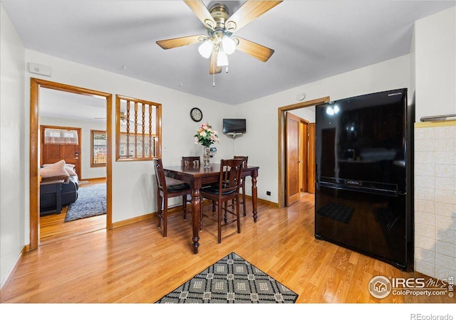 dining space featuring ceiling fan, light wood-type flooring, and baseboards