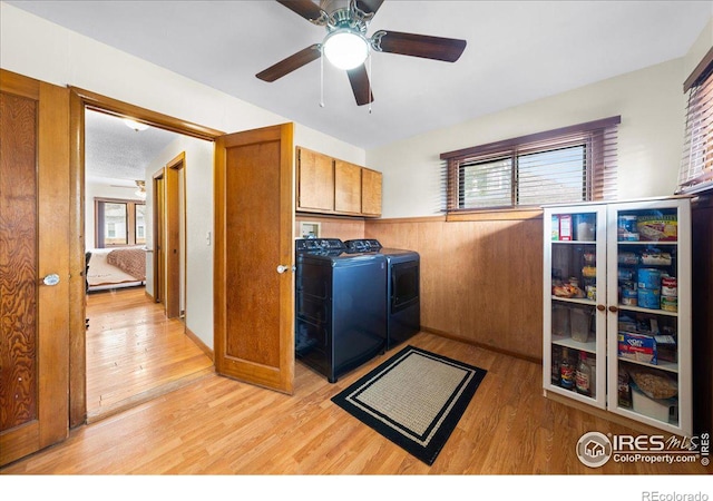 laundry area with light wood finished floors, cabinet space, and independent washer and dryer