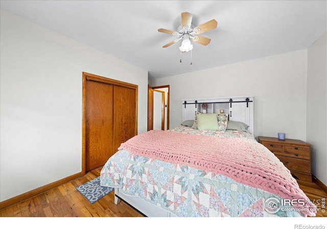 bedroom with ceiling fan, wood finished floors, a closet, and baseboards