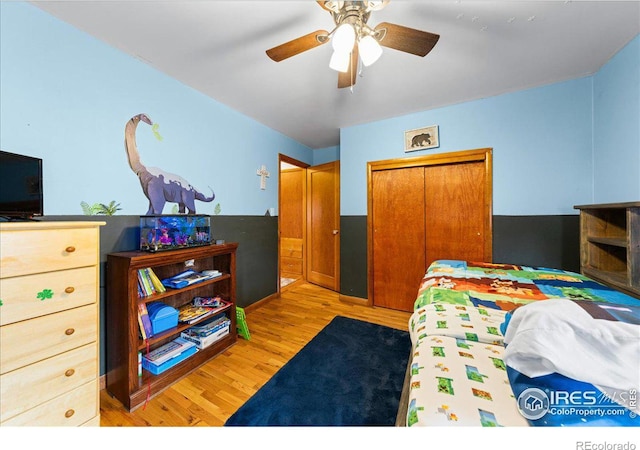 bedroom with a ceiling fan, light wood-style floors, and a closet