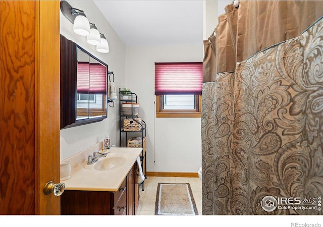 full bath featuring vanity and baseboards