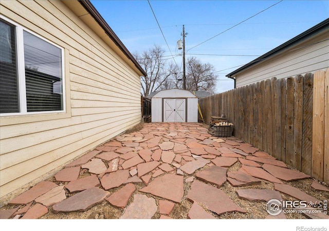 view of patio featuring a storage shed, an outdoor structure, and fence