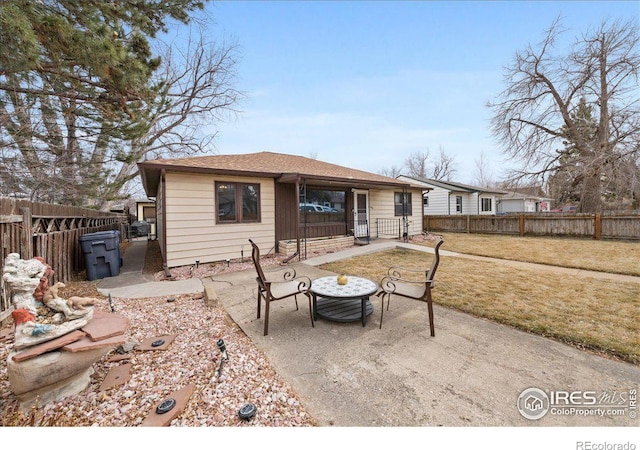 rear view of property with a yard, a patio area, and fence