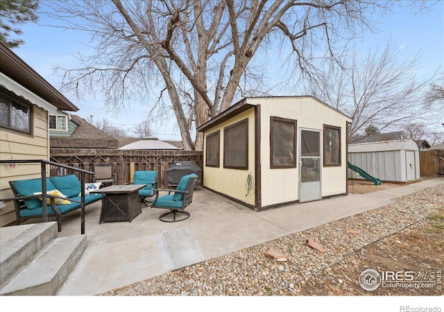 exterior space featuring a shed, a fire pit, an outdoor structure, and fence