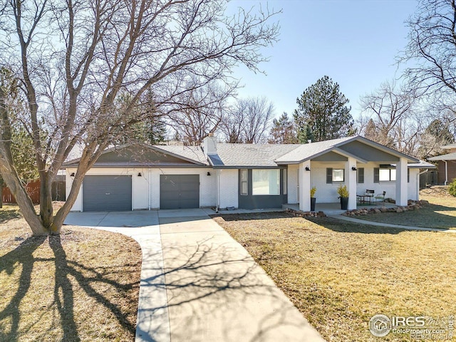 ranch-style home with a front yard, an attached garage, a chimney, concrete driveway, and brick siding