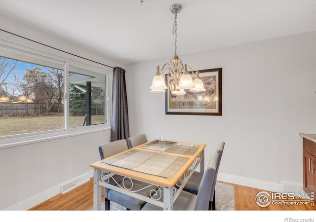 dining room with baseboards, visible vents, and light wood-type flooring