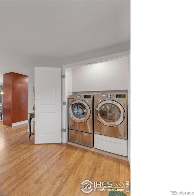 laundry room with laundry area, light wood-style flooring, and washing machine and dryer