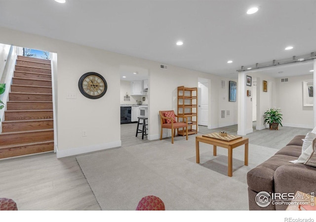 living area with wood finished floors, stairway, recessed lighting, and visible vents