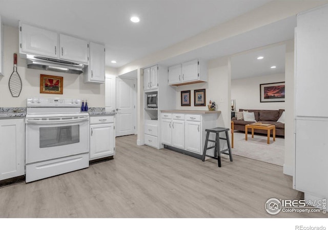 kitchen with under cabinet range hood, light wood-type flooring, stainless steel microwave, and white range with electric cooktop