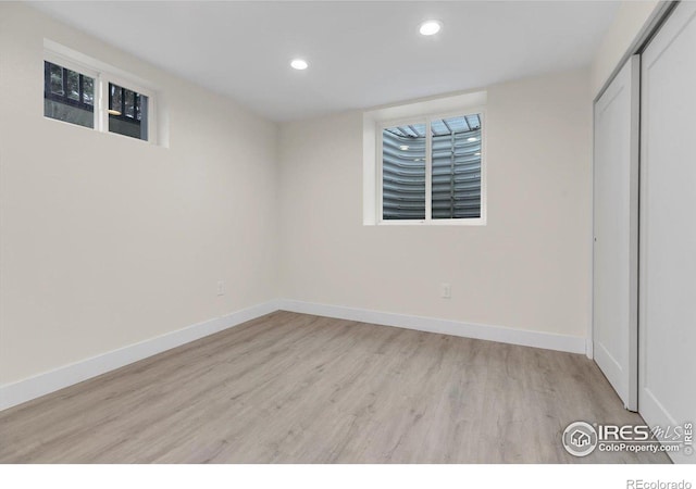 finished basement featuring recessed lighting, light wood-style floors, and baseboards