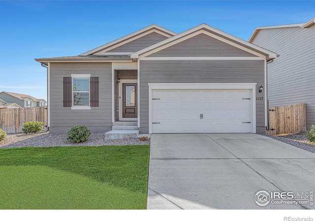 ranch-style house with a front yard, concrete driveway, an attached garage, and fence