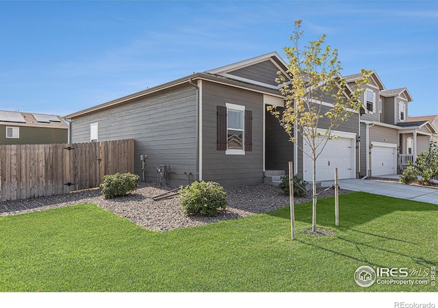 view of front of house with driveway, an attached garage, a front lawn, and fence