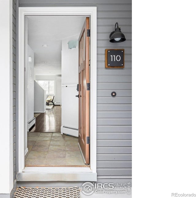 entrance to property with a baseboard heating unit and a baseboard radiator