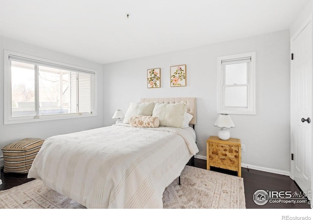 bedroom with dark wood-type flooring and baseboards