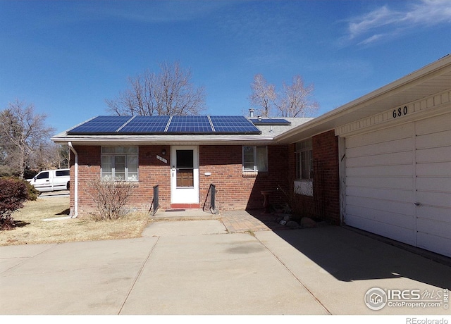 view of front of house with brick siding and roof mounted solar panels