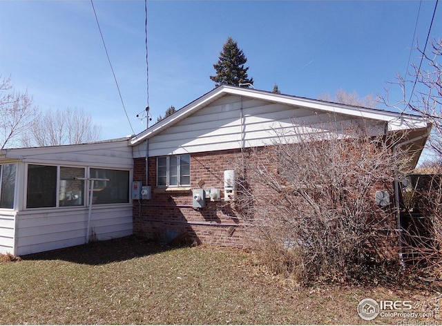 view of side of property featuring a yard and brick siding