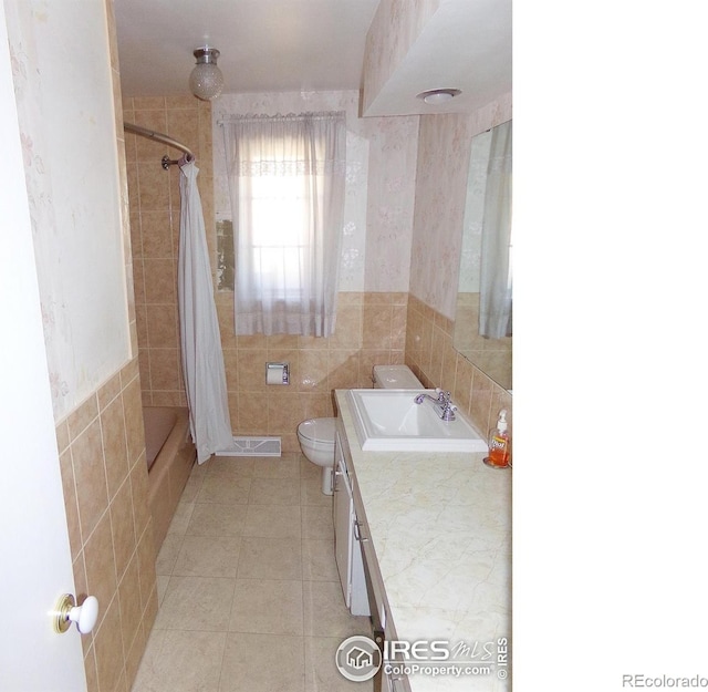 full bathroom featuring curtained shower, toilet, tile walls, and tile patterned flooring