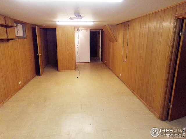 finished basement featuring wooden walls and light floors