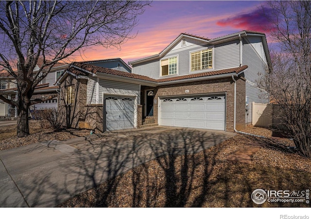 3937 Kenwood Cir, Johnstown, CO 80534 - traditional-style home featuring a garage, brick siding, driveway, and a tiled roof