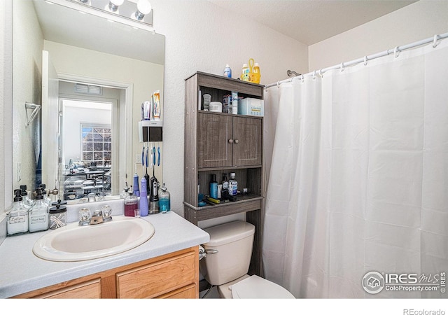 3937 Kenwood Cir, Johnstown, CO 80534 - bathroom featuring toilet, vanity, and a textured wall