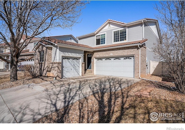 3937 Kenwood Cir, Johnstown, CO 80534 - traditional-style house featuring brick siding, fence, a tile roof, concrete driveway, and a garage