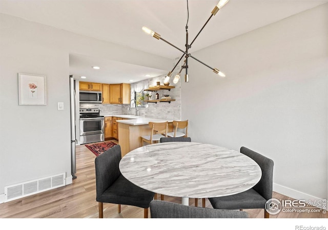 dining room with light wood-type flooring, visible vents, baseboards, and recessed lighting