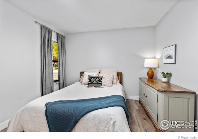 bedroom with baseboards and wood finished floors