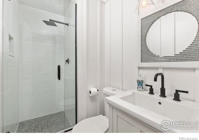 bathroom featuring vanity, toilet, and a shower stall