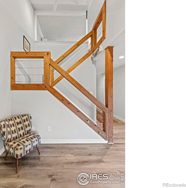 staircase with baseboards and wood finished floors