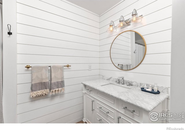 bathroom featuring wood walls and vanity