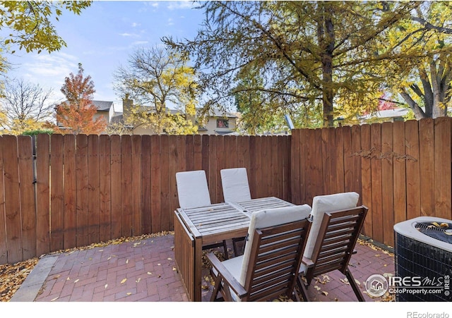 view of patio / terrace featuring central AC unit and fence