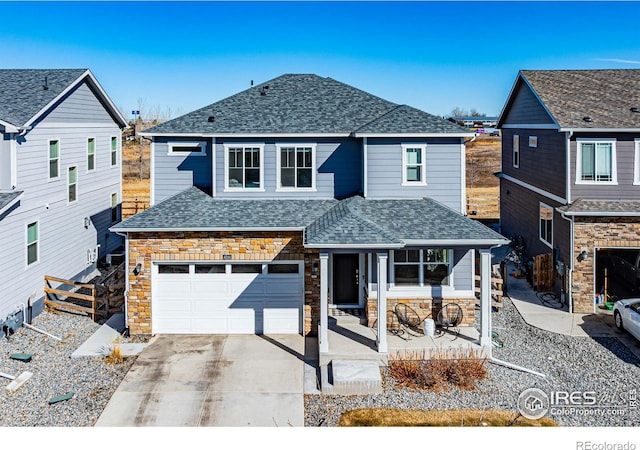 traditional-style house featuring fence, a shingled roof, concrete driveway, a garage, and stone siding