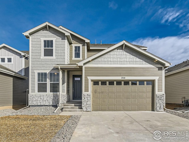 craftsman-style house featuring concrete driveway, a garage, and stone siding