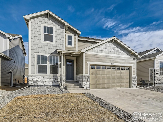 craftsman-style house featuring stone siding, an attached garage, and driveway