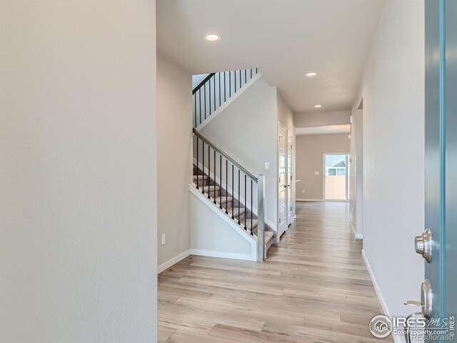 foyer entrance with recessed lighting, stairs, light wood-type flooring, and baseboards