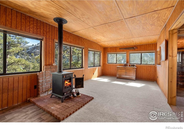 224 Loveland Heights Ln, Drake, CO 80515 - interior space with carpet, lofted ceiling, a wood stove, wood ceiling, and wood walls