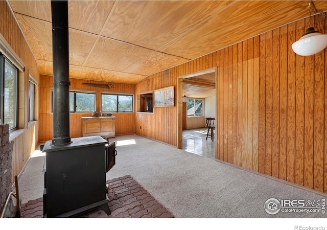 224 Loveland Heights Ln, Drake, CO 80515 - spare room with wooden ceiling, a wood stove, carpet flooring, and wood walls