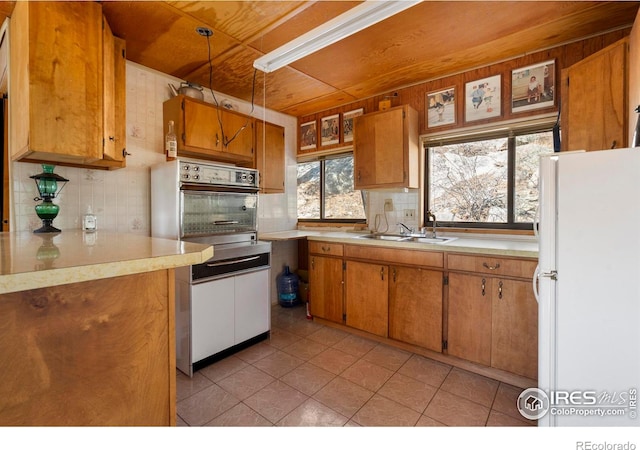 224 Loveland Heights Ln, Drake, CO 80515 - kitchen featuring brown cabinetry, freestanding refrigerator, a sink, light countertops, and wall oven