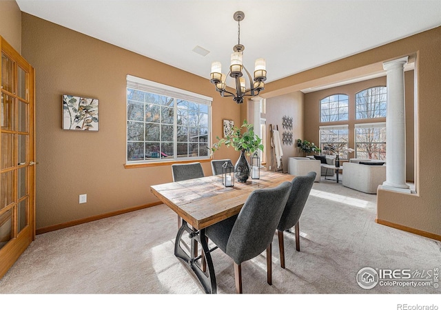 dining area with baseboards, light carpet, plenty of natural light, and ornate columns