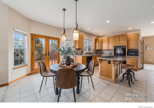 kitchen with light tile patterned floors, french doors, tasteful backsplash, and a center island