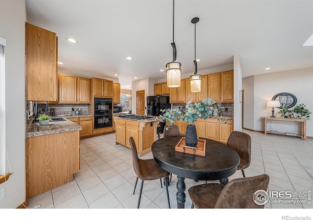 kitchen with light tile patterned flooring, a kitchen island, black appliances, and tasteful backsplash