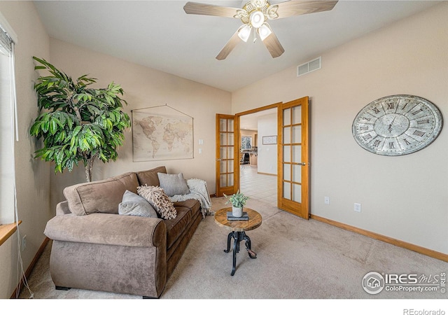 carpeted living area featuring a ceiling fan, french doors, visible vents, and baseboards