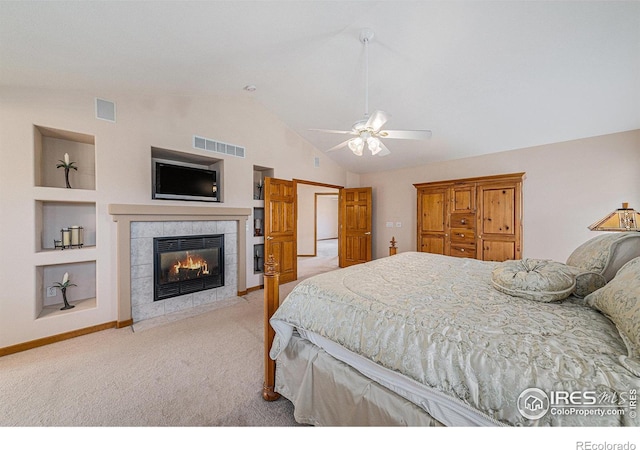 bedroom with a tiled fireplace, visible vents, light colored carpet, and lofted ceiling